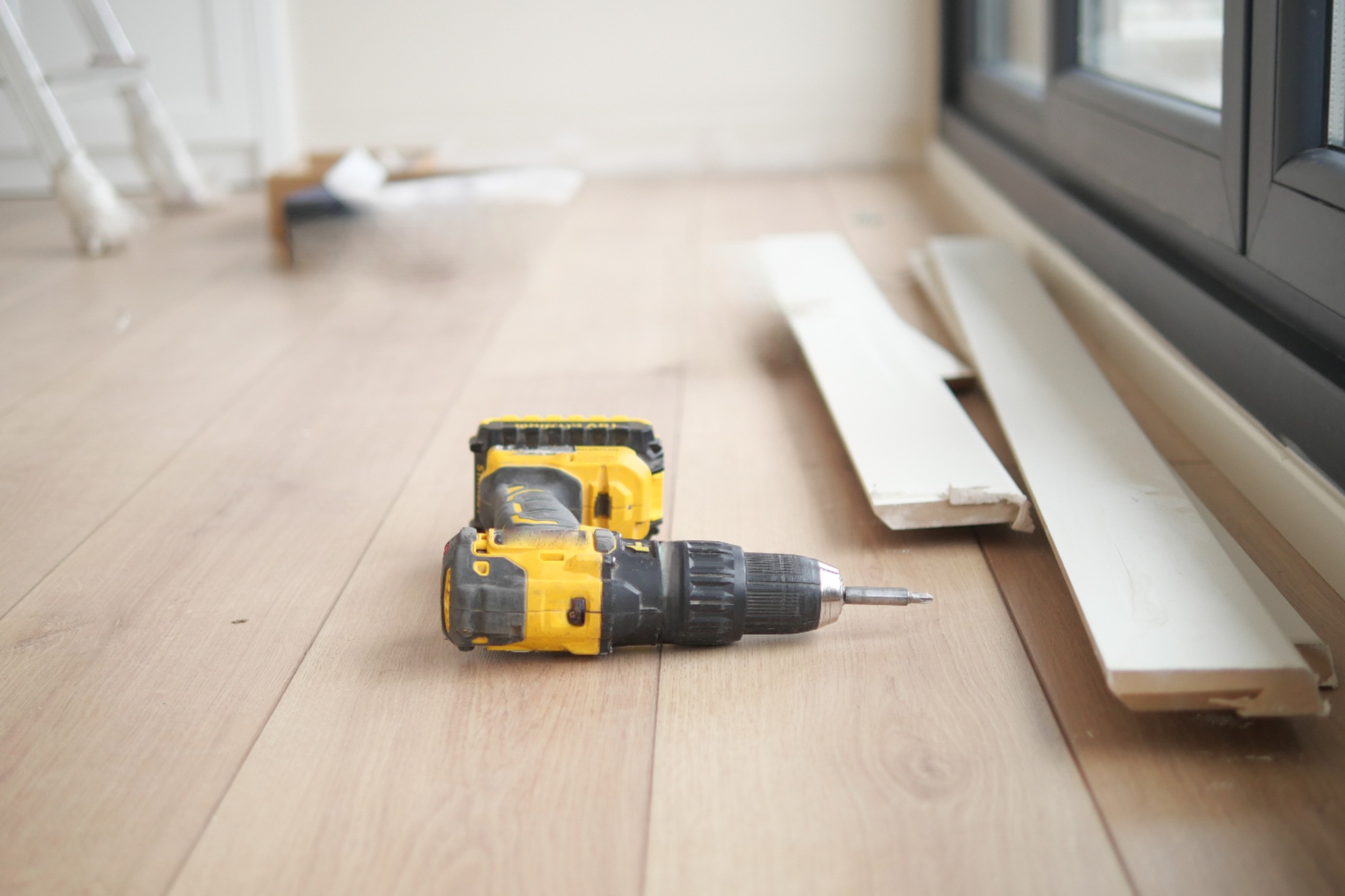 An electric screwdriver is on the floor,