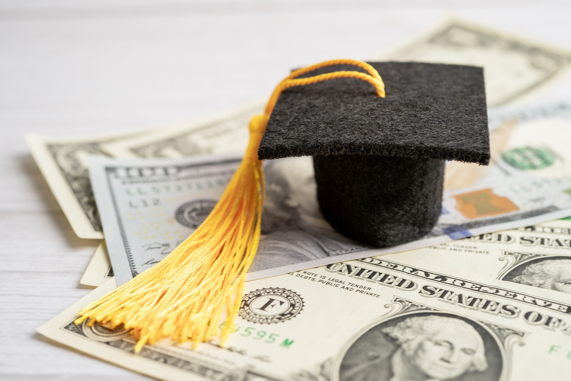 Graduation gap hat on US dollar banknotes money, Education study fee learning teach concept.